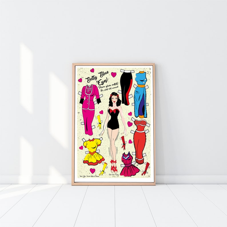 May include: A vintage-style paper doll of "Betty Blue Eyes!" with a variety of outfits to choose from, including a pink dress, a yellow dress, a red dress, a blue dress, and a black swimsuit. The paper doll is on a cream background with pink hearts.