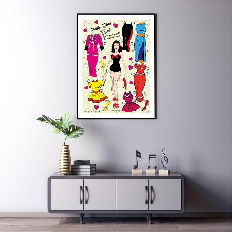 May include: A vintage paper doll set featuring a woman named "Betty Blue Eyes". The doll has different outfits to choose from, including a pink suit, a yellow dress, a red dress, a blue dress, and a black swimsuit. The paper doll set is printed on a cream-colored background with pink hearts.