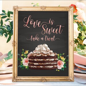 May include: A gold framed chalkboard sign with the text "Love is Sweet take a treat" in pink script. A chocolate cake with marshmallow frosting and floral accents is pictured below the text.