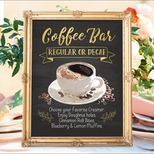K&ouml;nnte beinhalten: Ein goldfarbener Rahmen um ein Schild aus schwarzem Schiefer mit dem Text "Coffee Bar" in goldenen Buchstaben. Das Schild sagt auch "Regular oder Decaf" und enth&auml;lt eine Zeichnung einer Tasse Kaffee mit Kaffeebohnen. Der Text unter der Zeichnung lautet "W&auml;hlen Sie Ihren Lieblingskaffeewei&szlig;er. Genie&szlig;en Sie Donut-L&ouml;cher. Zimtschnecken-Bissen. Blaubeer- und Zitronenmuffins."