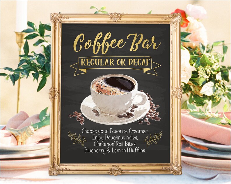 K&ouml;nnte beinhalten: Ein goldfarbener Rahmen um ein Schild aus schwarzem Schiefer mit dem Text "Coffee Bar" in goldenen Buchstaben. Das Schild sagt auch "Regular oder Decaf" und enth&auml;lt eine Zeichnung einer Tasse Kaffee mit Kaffeebohnen. Der Text unter der Zeichnung lautet "W&auml;hlen Sie Ihren Lieblingskaffeewei&szlig;er. Genie&szlig;en Sie Donut-L&ouml;cher. Zimtschnecken-Bissen. Blaubeer- und Zitronenmuffins."