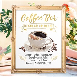 K&ouml;nnte beinhalten: Ein goldfarbener Rahmen mit dem Text "Coffee Bar" in goldener Schrift. Das Schild sagt auch "Regular oder Decaf" und enth&auml;lt eine Aquarell-Illustration einer Tasse Kaffee mit Kaffeebohnen. Der Text unter der Illustration lautet "W&auml;hlen Sie Ihren Lieblingskaffeewei&szlig;er. Genie&szlig;en Sie Doughnut-L&ouml;cher. Zimtschnecken-Bissen. Blaubeer- und Zitronenmuffins."