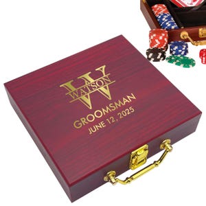May include: A burgundy wooden poker set case with gold hardware and handle. The case is engraved with the name "WATSON" and the text "GROOMSMAN JUNE 12, 2025". Poker chips in various colors are visible.
