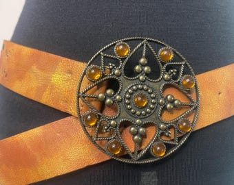 Vintage genuine leather belt in metallic orange color with round buckle and amber color stones
