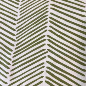 May include: A fabric with a repeating pattern of olive green diagonal lines on a white background. The lines are thick and slightly rounded, creating a textured, chevron-like design. This textile is suitable for various craft projects.