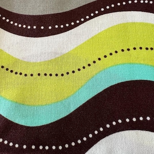 May include: Abstract fabric pattern featuring wavy stripes in teal, lime green, brown, gray, and white. Each stripe is accented with a dotted line. The fabric has a textured appearance.