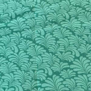 May include: Close-up of a teal fabric with a repeating pattern of stylized, leafy shapes. The design creates a textured, organic appearance, suitable for various craft and sewing projects. The fabric's color is a vibrant, medium teal.