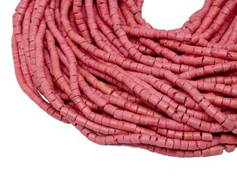 May include: A strand of pink coral beads, each bead is a small cylinder with a rough texture.