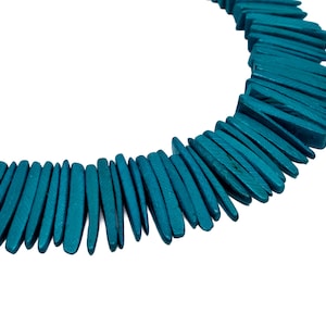 May include: A teal blue necklace made of wooden beads. The beads are long and narrow, resembling small, flat sticks.