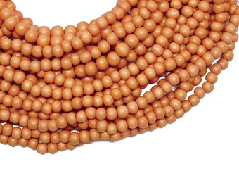 May include: A strand of orange wood beads. The beads are round and smooth, and they are strung together on a string.
