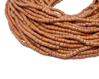 May include: Close-up of a pile of small, cylindrical beads in a warm, earthy brown color. The beads are strung together, creating a coiled shape against a white background. These beads are suitable for jewelry making and crafting.