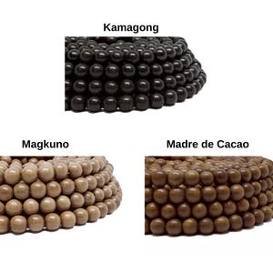 May include: Three strands of wooden beads in different colors. The top strand is black, the middle strand is light brown, and the bottom strand is dark brown.