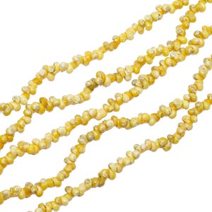 May include: Strands of small, irregularly shaped, yellow and off-white beads. The beads are strung together, creating a textured, organic look. The background is plain white, highlighting the jewelry.