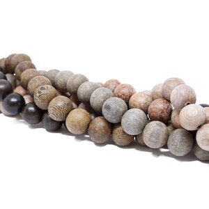 May include: A strand of wooden beads in various shades of brown, gray, and black. The beads are round and have a natural, rustic look.