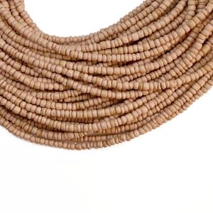 May include: A long strand of light brown wooden beads, arranged in a curved shape, resembling a necklace.