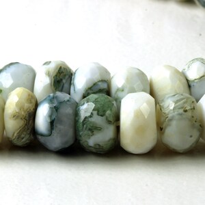 Puede incluir: Un collar de cuentas de piedras preciosas facetadas. Las cuentas son blancas y verde pálido, con un patrón moteado. Las cuentas están ensartadas, adecuadas para un collar o pulsera.