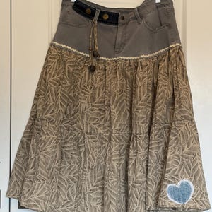 Falda de patchwork de algodón y mezclilla reciclada: telas recuperadas, cintura ajustable, estilo bohemio, botones metálicos.