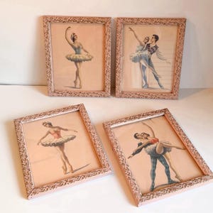May include: Four framed ballet art prints. Each print features a ballerina or a couple in ballet poses. The frames are a light pink with ornate detailing. The ballet dancers are wearing tutus and performing ballet moves.