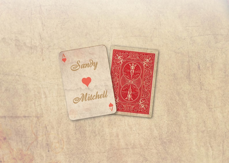 Peut inclure: Deux cartes &agrave; jouer sur un fond textur&eacute;. L'une est l'As de c&oelig;ur, personnalis&eacute;e avec les noms "Sandy" et "Mitchell" et un c&oelig;ur rouge. L'autre carte montre le dos rouge d'une carte &agrave; jouer.