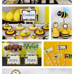 May include: A yellow and black bumble bee themed birthday party with a cake, cupcakes, cookies, and pops. The cake is decorated with a beehive and bees. The cupcakes are decorated with bees and the number 1. The cookies are decorated with bees. The pops are decorated with bees and flowers. The banner says "Happy Birthday".