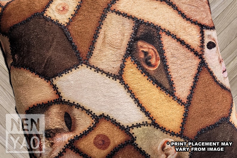 Close up of texture on handmade square pillow on wood floor made of minky fleece fabric featuring an original patchwork print of multiple shades of human skin and body parts stitched together including haunted faces, ears, elbows, and nipples.