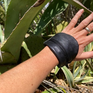 Monedero pequeño de muñeca, brazalete de cuero negro, para festival o concierto.