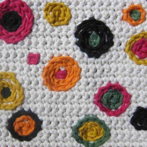 May include: White crocheted fabric with colorful embroidered circles. The circles are in various colors, including pink, yellow, orange, green, and black.