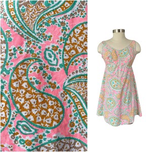 May include: A sleeveless pink dress with a paisley pattern in shades of brown, green, and white.