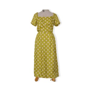May include: A green maxi dress with white polka dots. The dress has a square neckline and short sleeves.