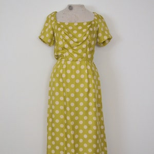 May include: A yellow dress with white polka dots. The dress has a square neckline and short sleeves. It is a midi length dress.
