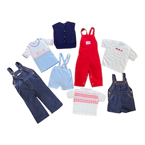 May include: A set of seven baby clothes, including two pairs of denim overalls, a red corduroy overall, a blue knitted vest, a white short-sleeved shirt with a blue and pink design, a white short-sleeved shirt with a red design, and a white short-sleeved sweater with a pink and red pattern.