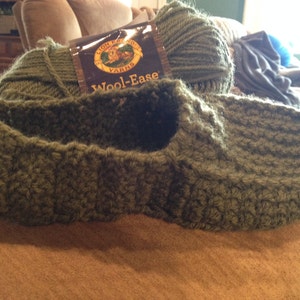 Pode incluir: Uma bola de lã verde com um rótulo que diz "Wool-Ease" da Lion Brand Yarn.