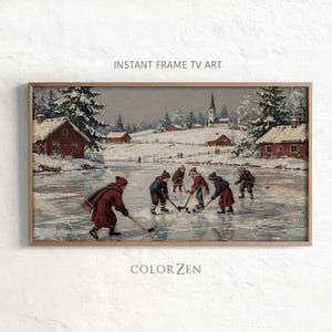 Könnte beinhalten: Ein rechteckiger Wandkunstdruck mit dem Titel INSTANT FRAME TV ART und COLOR ZEN, der eine winterliche Landschaftsmalerei zeigt, auf der Kinder auf einem zugefrorenen Teich Eishockey spielen. Zu sehen sind verschneite rote Holzhäuser und eine Kirche.