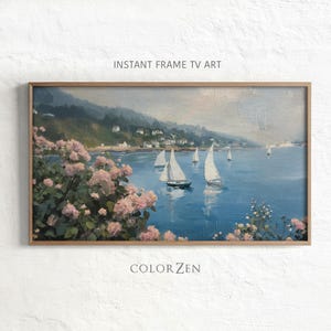 May include: A rectangular framed digital print titled INSTANT FRAME TV ART by COLOR ZEN featuring an oil painting of a coastal scene with white sailboats on blue water, a green hillside with houses, and foreground clusters of pink flowers.