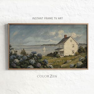 May include: A landscape painting in a wooden frame titled INSTANT FRAME TV ART by COLOR ZEN. The scene depicts a white house on a grassy hill overlooking a bay with a sailboat, framed by blue hydrangea bushes under a cloudy, overcast sky.