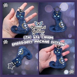 May include: A dark blue plush cat charm with celestial designs, including a sun, moon, and stars. The charm has a star-shaped keychain and is labeled as an embroidery machine pattern. The text "Dragons Garden" is also visible.