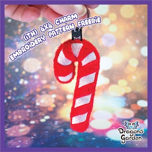 以下が含まれることがあります： 黒色のキーリングが付いた赤と白のキャンディーケーンチャーム。チャームはふわふわの生地で作られており、白い刺繍が施されています。画像のテキストは「(ITH) 4x4 CHARM EMBROIDERY PATTERN FREEBIE」です。