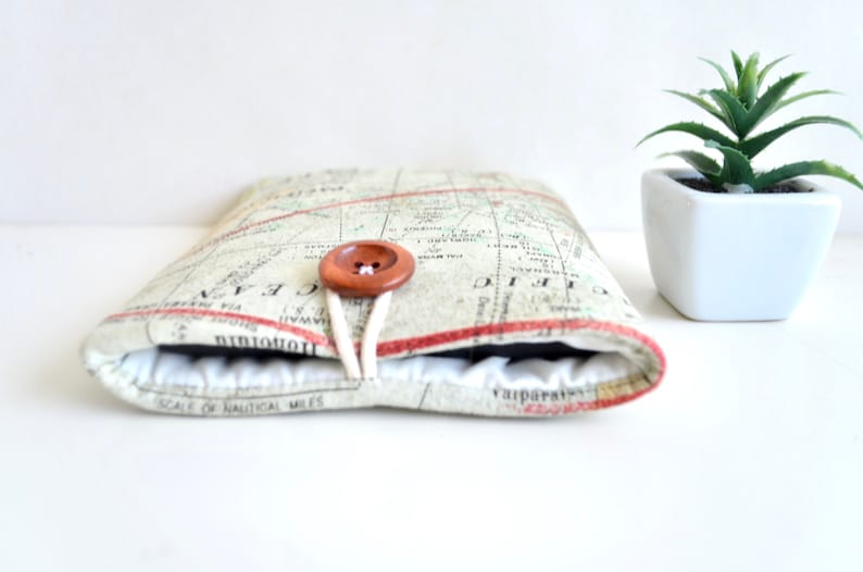 May include: A beige and brown fabric tablet case with a map print and a wooden button closure. The case is closed and the button is fastened.