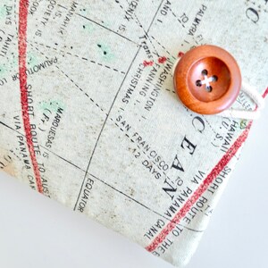 May include: A close-up of a vintage-style map with a wooden button and twine closure. The map features text such as "SHORT ROUTE TO THE OCEAN VIA PANAMA CANAL" and "EQUATOR".
