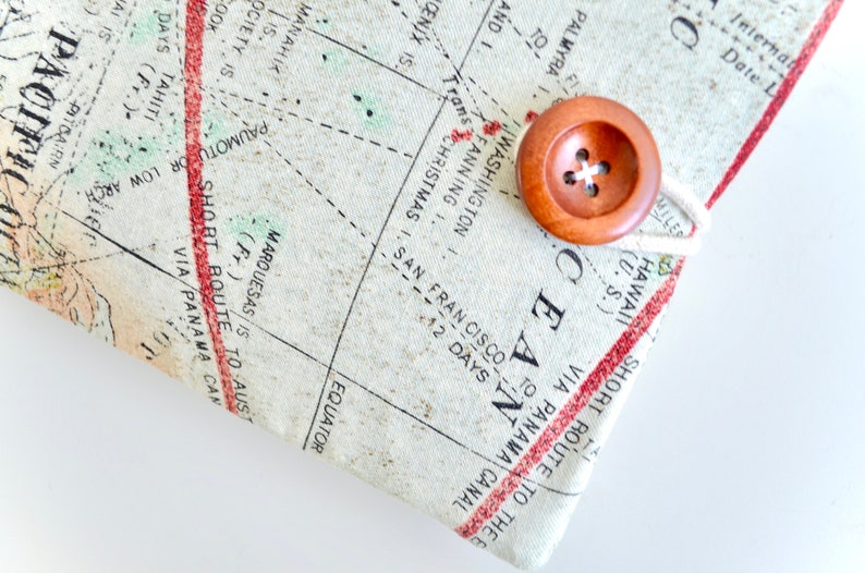 May include: A close-up of a vintage-style map with a wooden button and twine closure. The map features text such as "SHORT ROUTE TO THE OCEAN VIA PANAMA CANAL" and "EQUATOR".