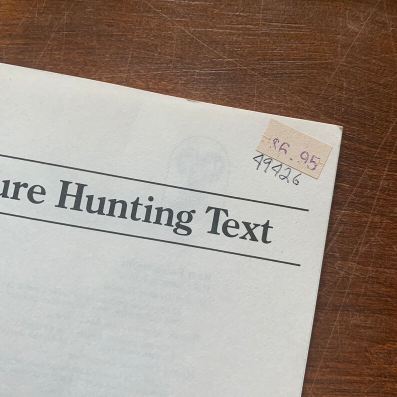May include: A white booklet with the text "Treasure Hunting Text" printed in black. A price tag with the text "$6.95" and the number "49426" is attached to the booklet.