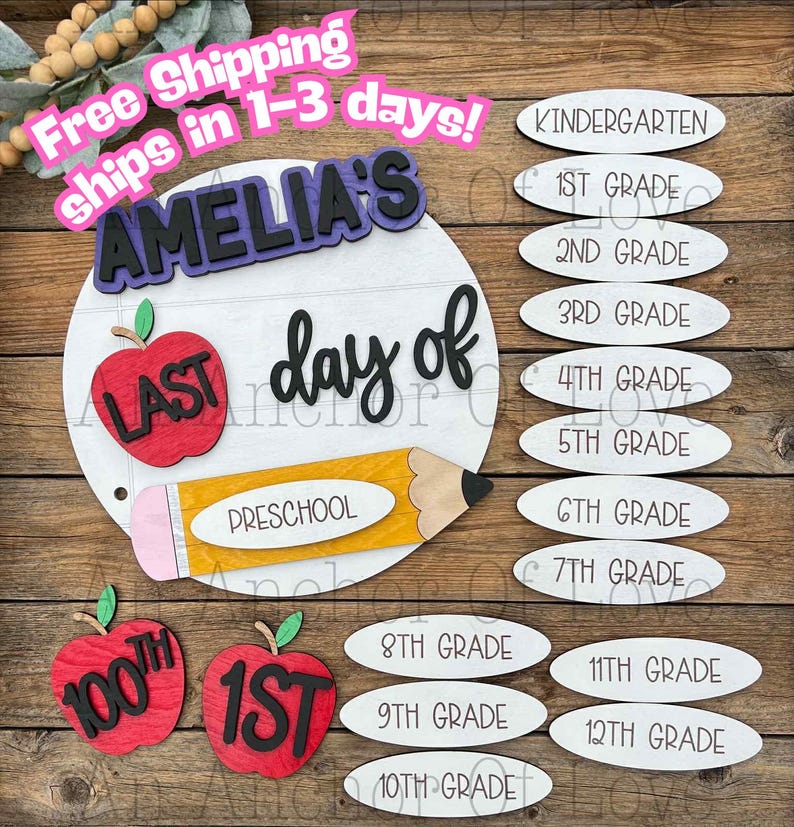 May include: A wooden school-themed sign with the text "AMELIA'S day of" and a pencil, apple, and grade level options. The sign includes the text "LAST" and "PRESCHOOL". Additional apple cutouts display "100th" and "1st".