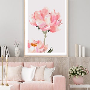May include: A framed print of a pink peony flower with a white background. The flower is in focus and the background is blurred.