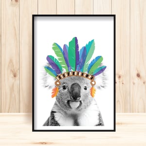 Puede incluir: Una foto en blanco y negro de un koala con un tocado de plumas de colores. El tocado est&aacute; hecho de plumas azules, verdes y moradas. El koala est&aacute; mirando directamente a la c&aacute;mara.