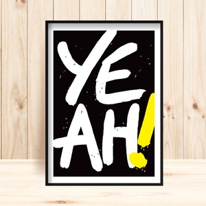 Könnte beinhalten: Schwarz-weißer Grafikdruck mit dem Wort "YEAH!" in fetten weißen Buchstaben auf schwarzem Hintergrund. Das Ausrufezeichen ist gelb.