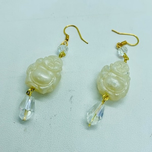 Pearl like acrylic sitting Buddha Swarovski drop chandelier earrings.