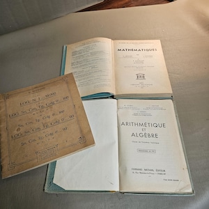 Peut inclure: Quatre manuels de mathématiques anciens ouverts, présentant du texte et des schémas. Les livres sont en état d'usage, avec du papier et des couvertures vieillis. Les titres incluent "Mathématiques" et "Arithmétique et Algèbre".
