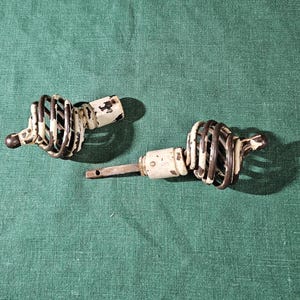May include: Two antique white and black metal door knobs with a spiral design.