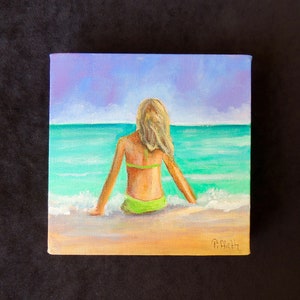 Beach painting of blonde sitting by the ocean&#39;s edge.  Original acrylic on gallery wrap square canvas measuring 6&quot; x 6.&quot;