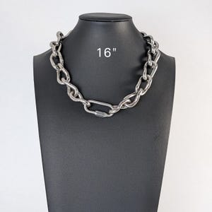 May include: A silver chain necklace with a clasp closure. The necklace is 16 inches long.